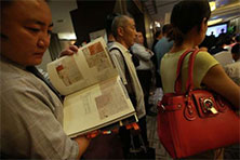 6月3日，北京一位参拍者正翻阅拍卖目录里的钱钟书书信手稿影印页